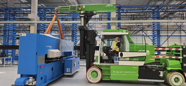 Żuraw przemysłowy ABT Services przenosi maszynę wewnątrz hali produkcyjnej podczas relokacji wewnętrznej